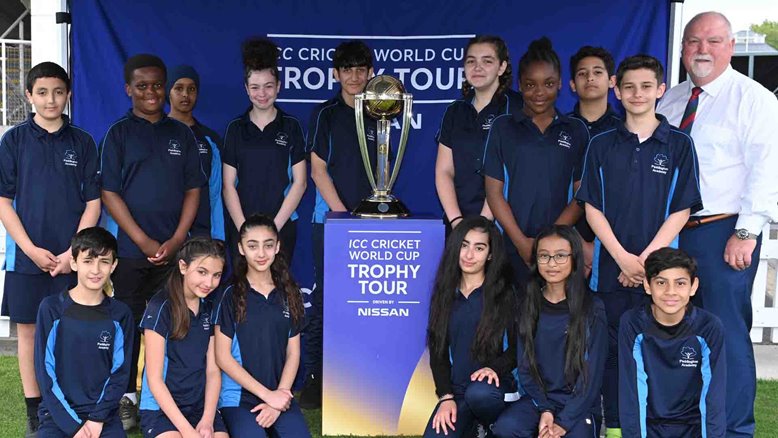 Mike Gatting and local school children pose with the World Cup trophy.